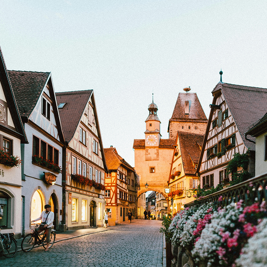Cobbled street in a quaint German town with historic buildings and a clock tower.