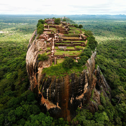 Zoomed out image of Sigiriya Rock Fortress in Sri Lanka surrounded by lush greenery